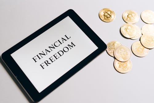Free Gold Coins Beside a Tablet  Stock Photo