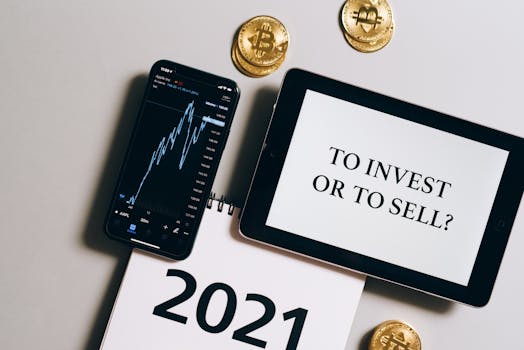 Overhead view of tablet, smartphone with chart, Bitcoin coins symbolizing investment choices for 2021.
