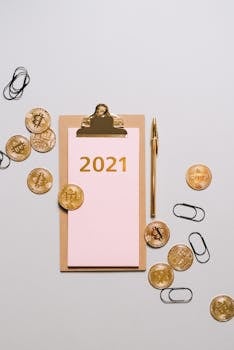 Flat lay of bitcoins with clipboard and 2021 text, conceptualizing planning and cryptocurrency.