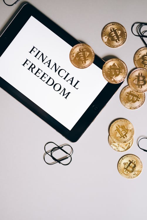 Free A Flatlay of Gold Coins and a Tablet Stock Photo