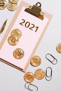 Golden Bitcoins on a clipboard with '2021' showcasing cryptocurrency concept in a flat lay style.