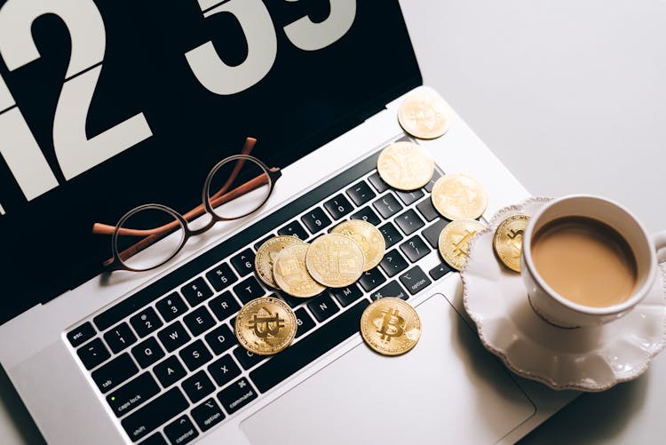 Gold Coins And A Cup Of Coffee On A Laptop