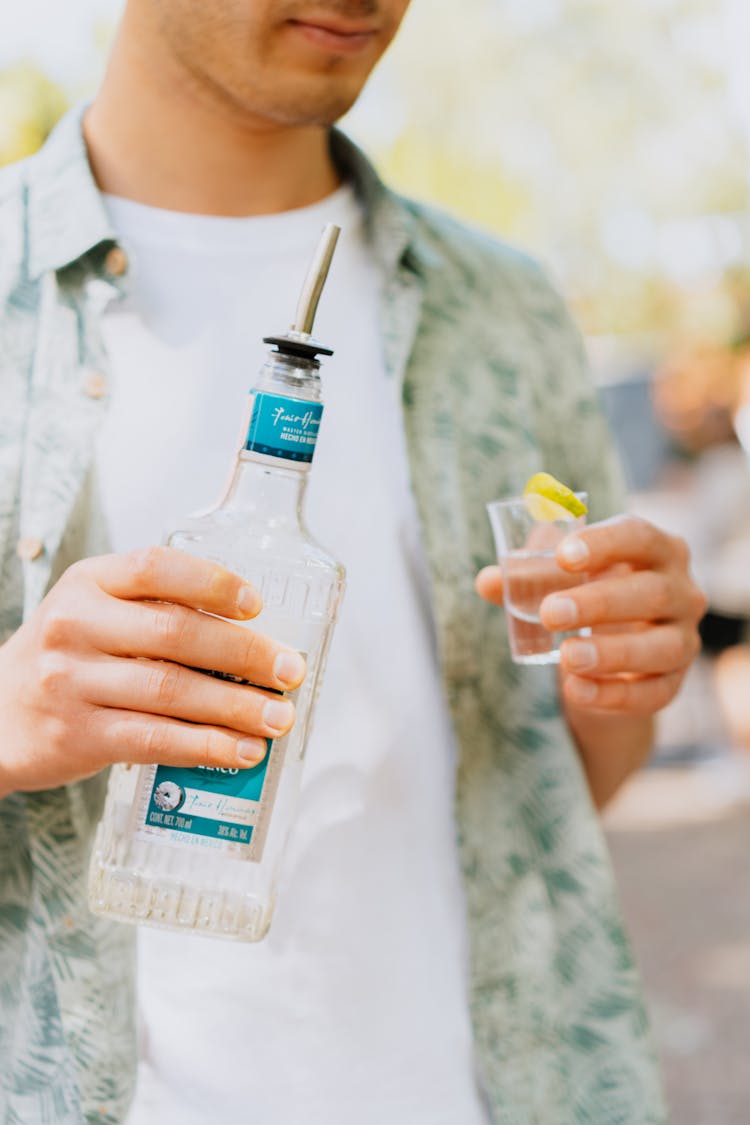 Close-Up Shot Of A Person Holding A Bottle Of Tequila