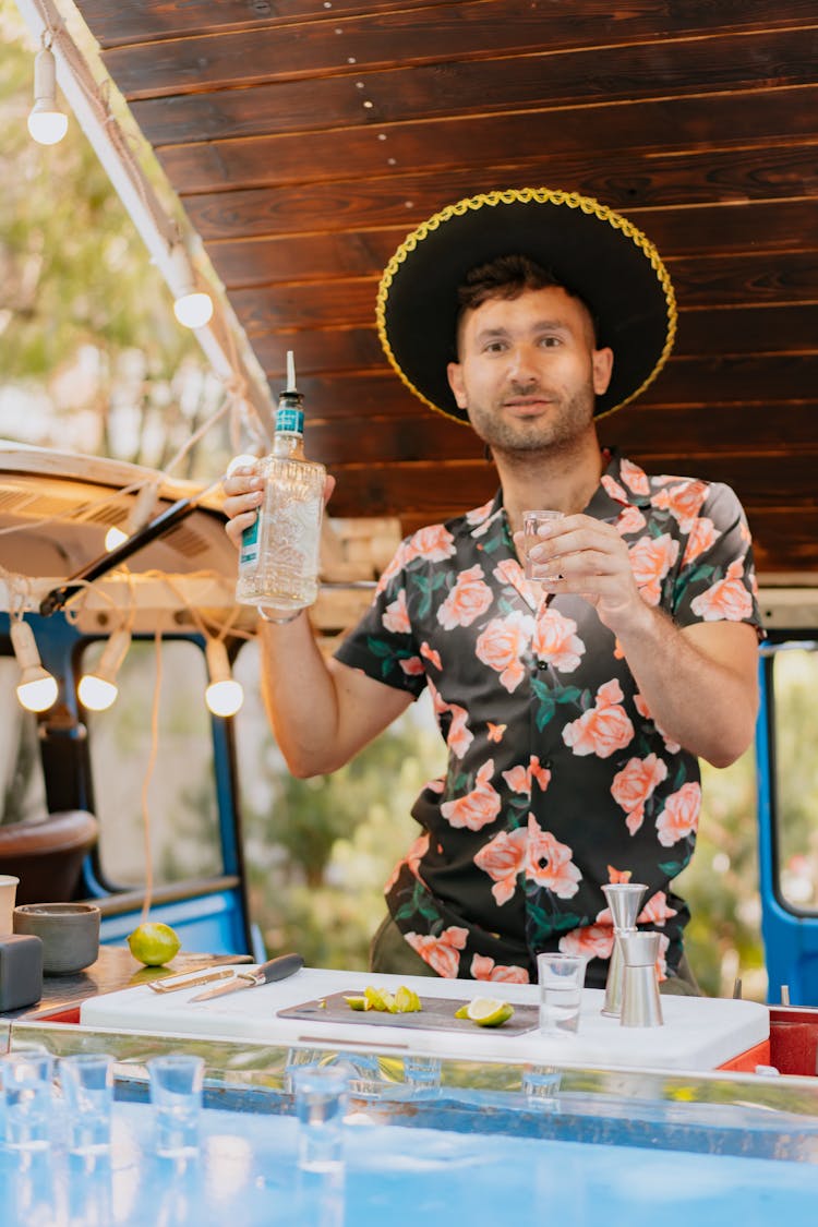 Man In Hat And Shirt Holding Bottle With Drink