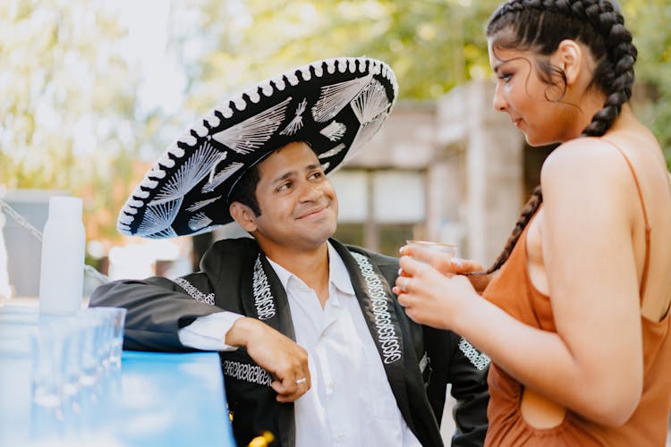 Man In Sombrero And A Woman Having A Drink 