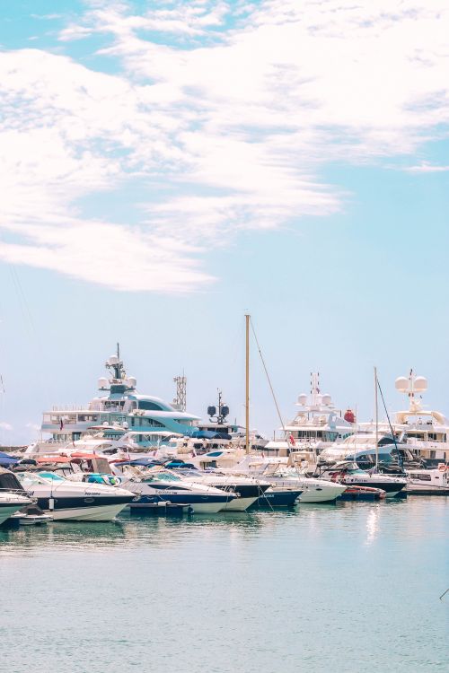 Free A picturesque scene of luxury yachts docked at the Sochi marina under a bright blue sky. Stock Photo