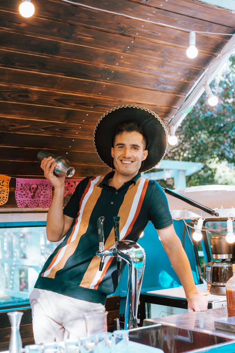 Bartender In A Sombrero Hat Standing Behind A Bar Counter 