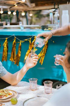 A lively outdoor scene with people enjoying drinks and food.