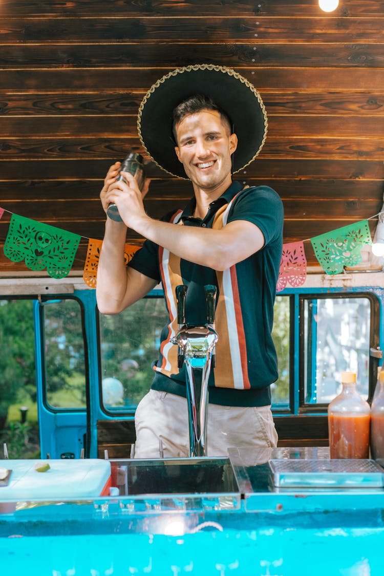 A Happy Bartender In A Sombrero At A Bar