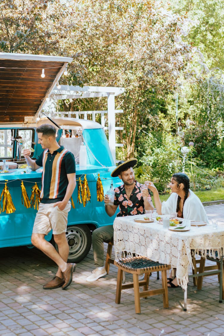 Men Drinking And Eating  In Outdoor Setting