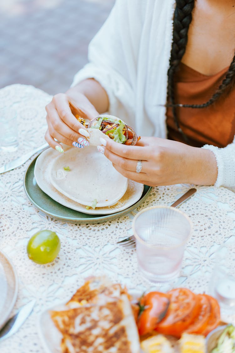 A Woman Eating Tortilla Wrap With Salas Filling