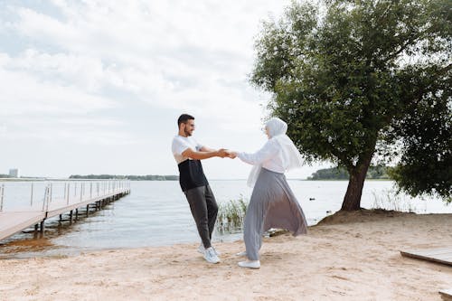 A Couple Holding Hands in the Lakeshore