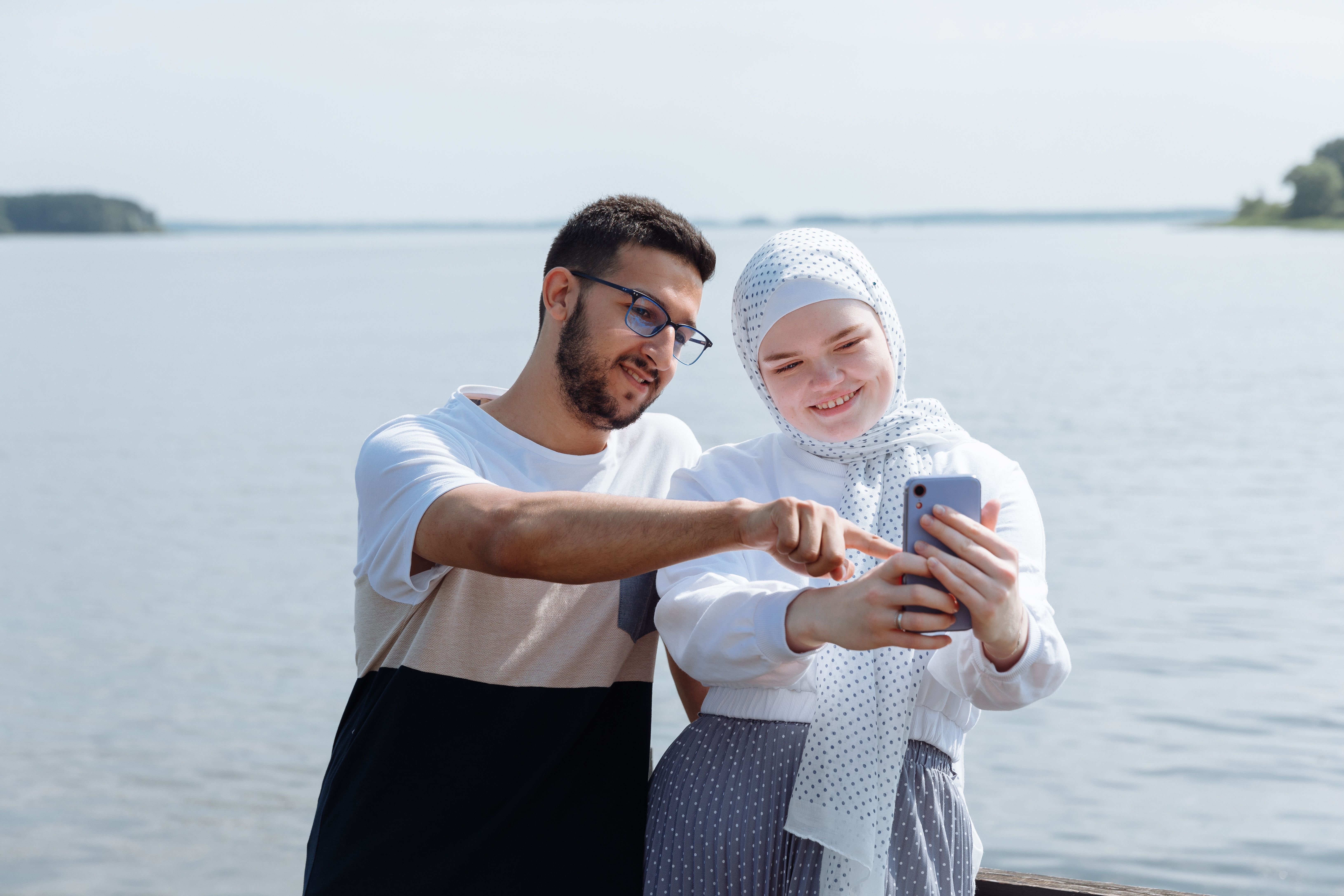 Muslim couple sharing a quiet moment together beside a lake