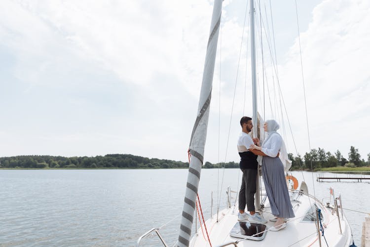 A Couple Standing O White Sailboat