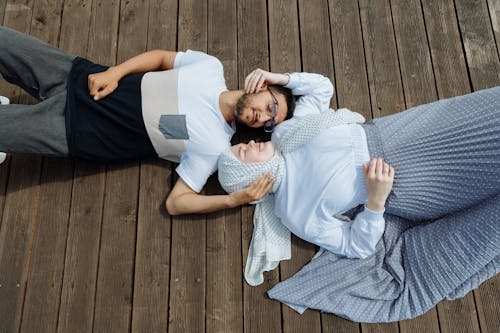 A Couple Lying Down on a Wooden Dock