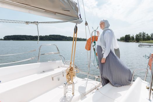A Woman in Hijab Standing in a Boat Stern