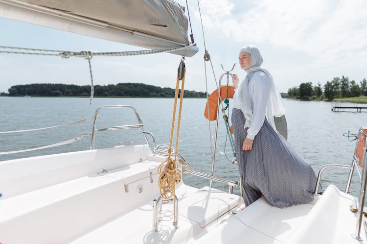 A Woman In Hijab Standing In A Boat Stern