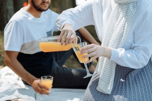 A Couple Having Juice in a Picnic