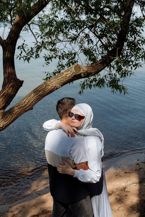 Free Photo of a Woman with a White Hijab Hugging a Man Stock Photo