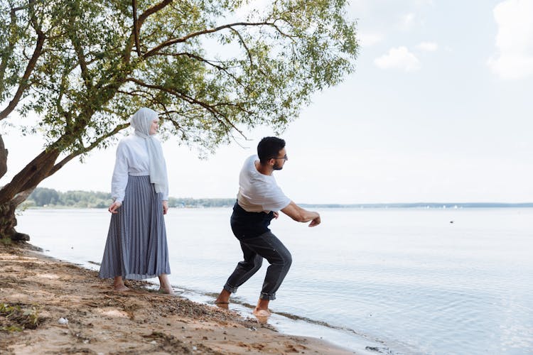 A Romantic Couple Playing On The Beach