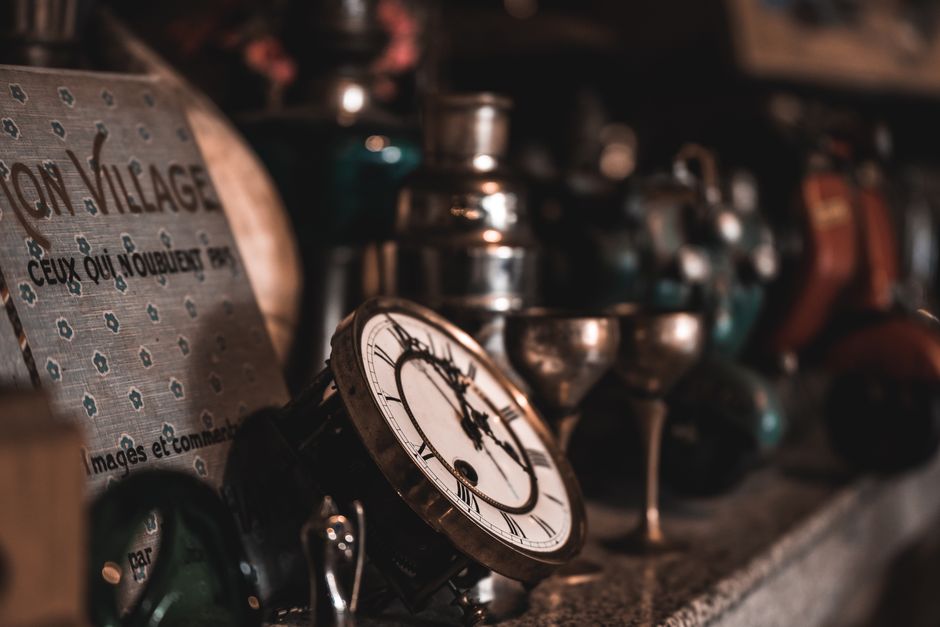 A close-up view of vintage clocks and antique items on a shelf, creating a nostalgic feel. A close-up view of vintage clocks and antique items on a shelf, creating a nostalgic feel.