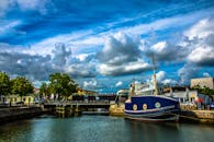 施特拉尔松德港的景色充满活力，背景中有一艘帆船、蓝天和一座桥