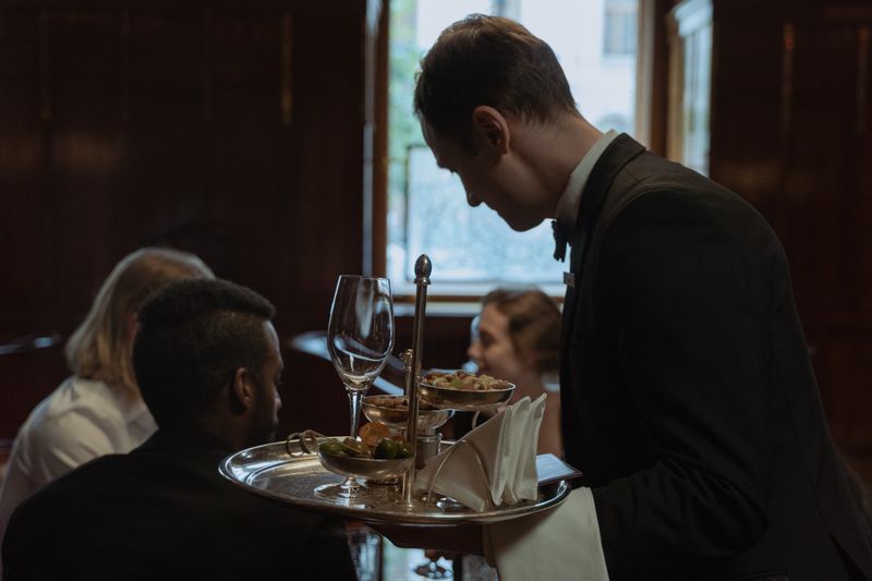 Ospătar servind vin invitaților