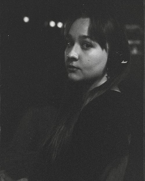 Free Expressive monochrome portrait of a woman with a contemplative look in a dimly lit setting. Stock Photo