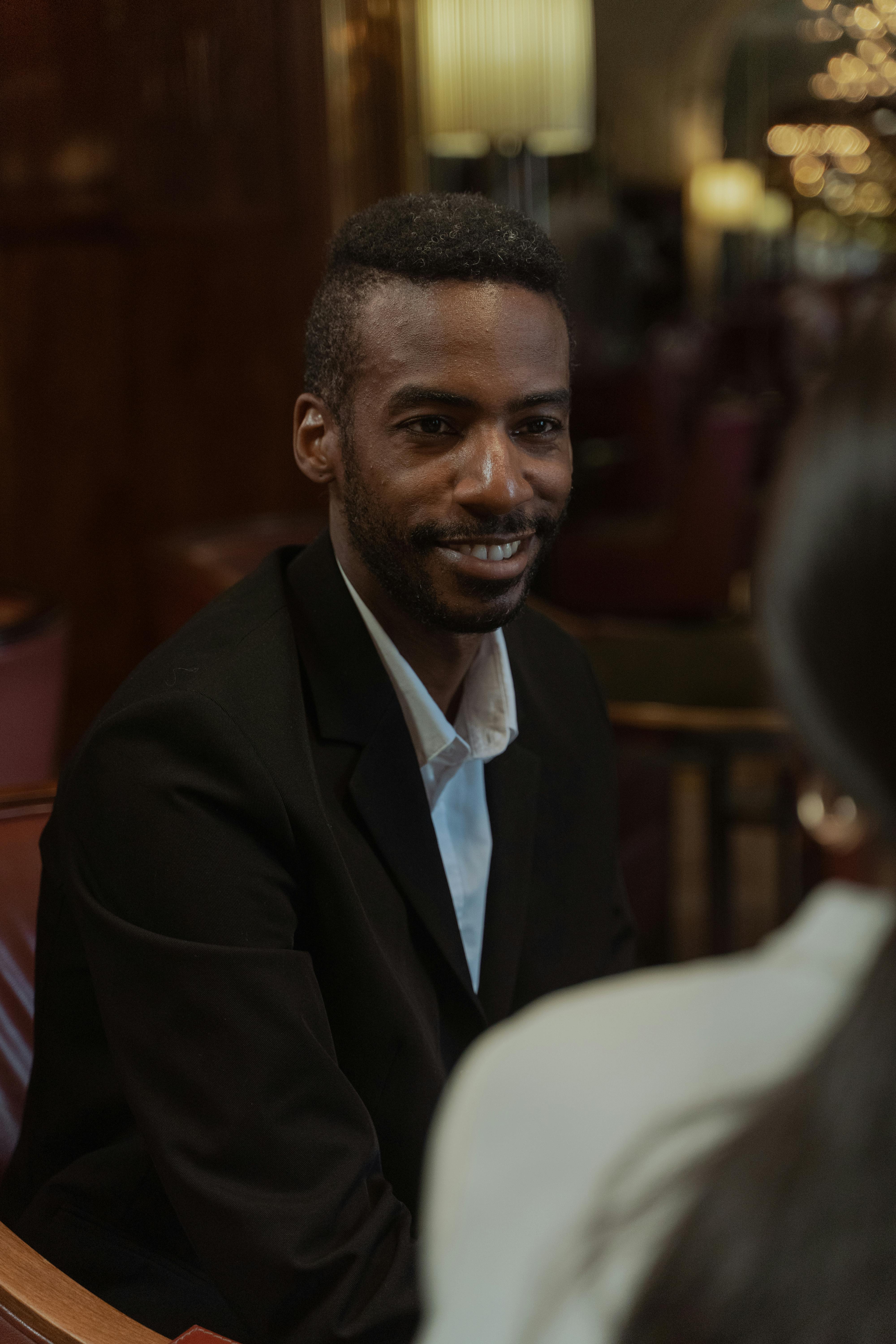 photo of a man in a black blazer smiling
