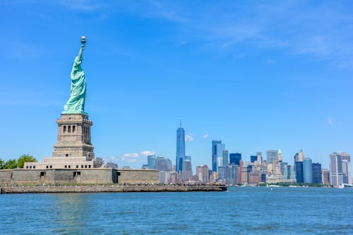 Free The Statue of Liberty with a view of One World Trade Center in New York City Stock Photo