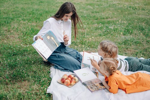 Free A Woman Tutoring Kids with Text Books Stock Photo