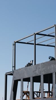 A modern structure under construction with visible railings and clear blue sky.
