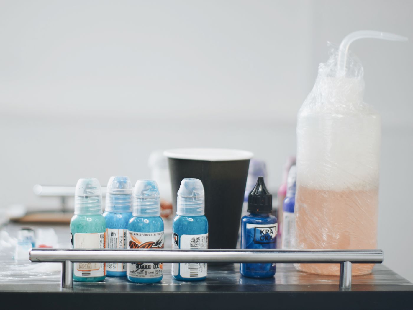Tattoo ink bottles and supplies on a studio workstation