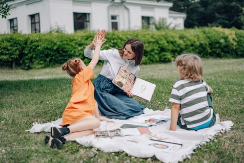 Free A teacher engaging with children in an outdoor reading session, showcasing education and interaction. Stock Photo