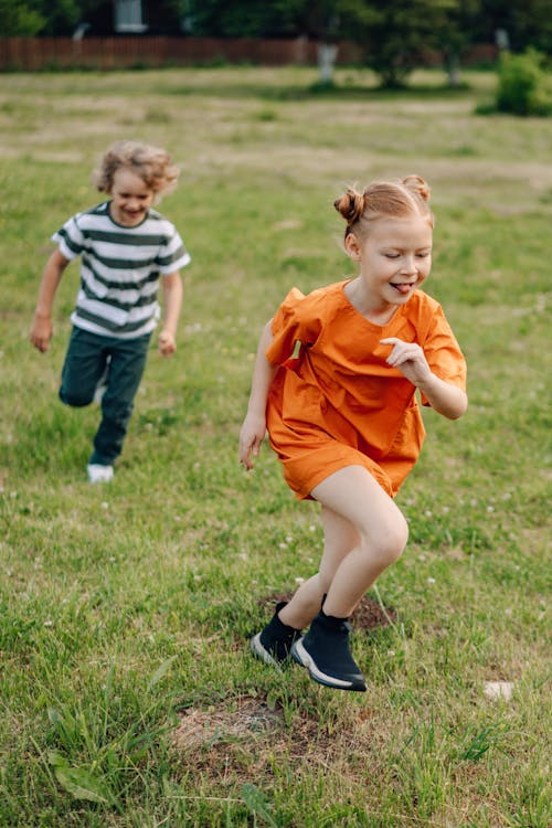 Boy and Girl Running On Grass