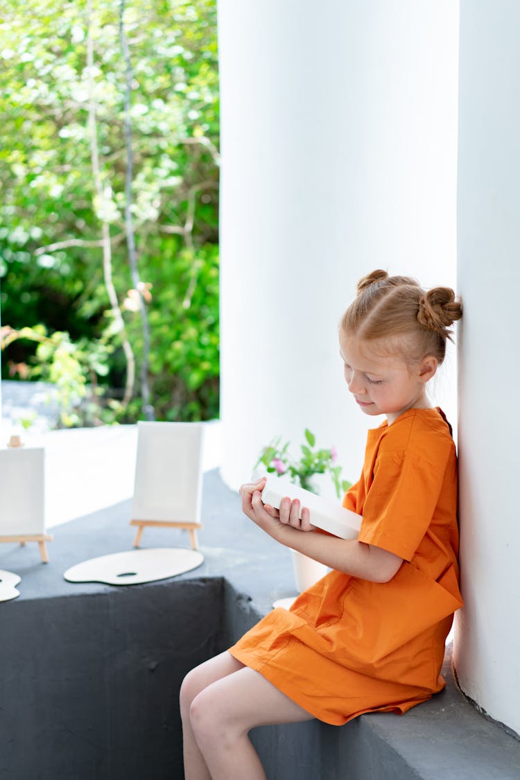 A Girl Holding A Painting Canvas