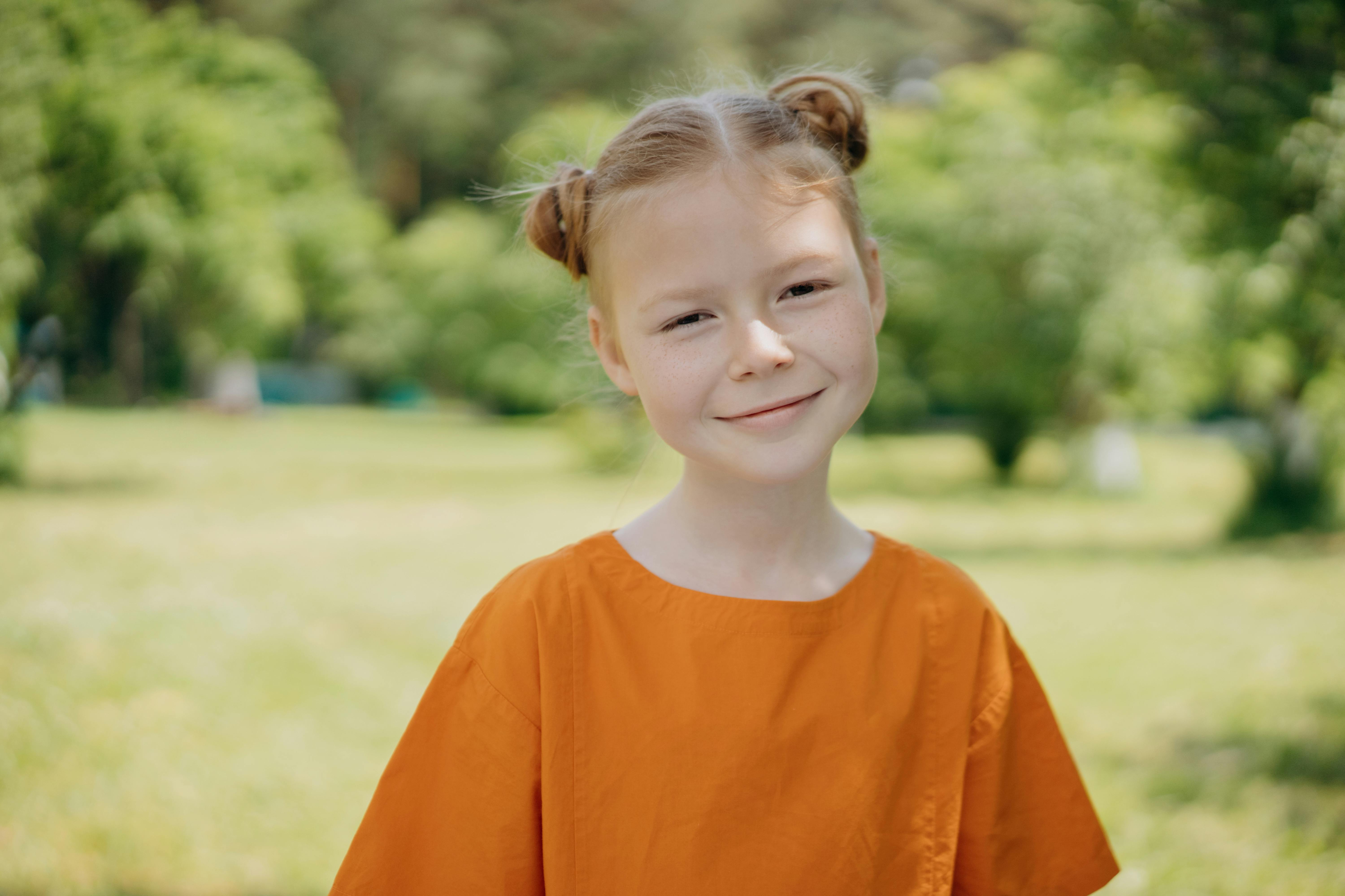 Adorable niña pequeña con camiseta naranja Foto de stock