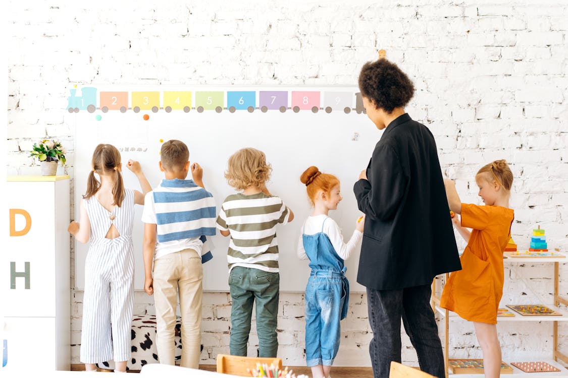 Children writing on white board