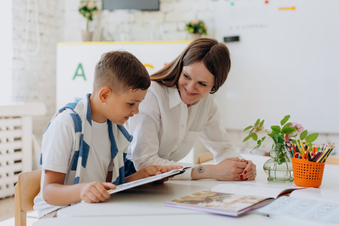 Lehrkraft unterstützt einen Schüler beim Lernen