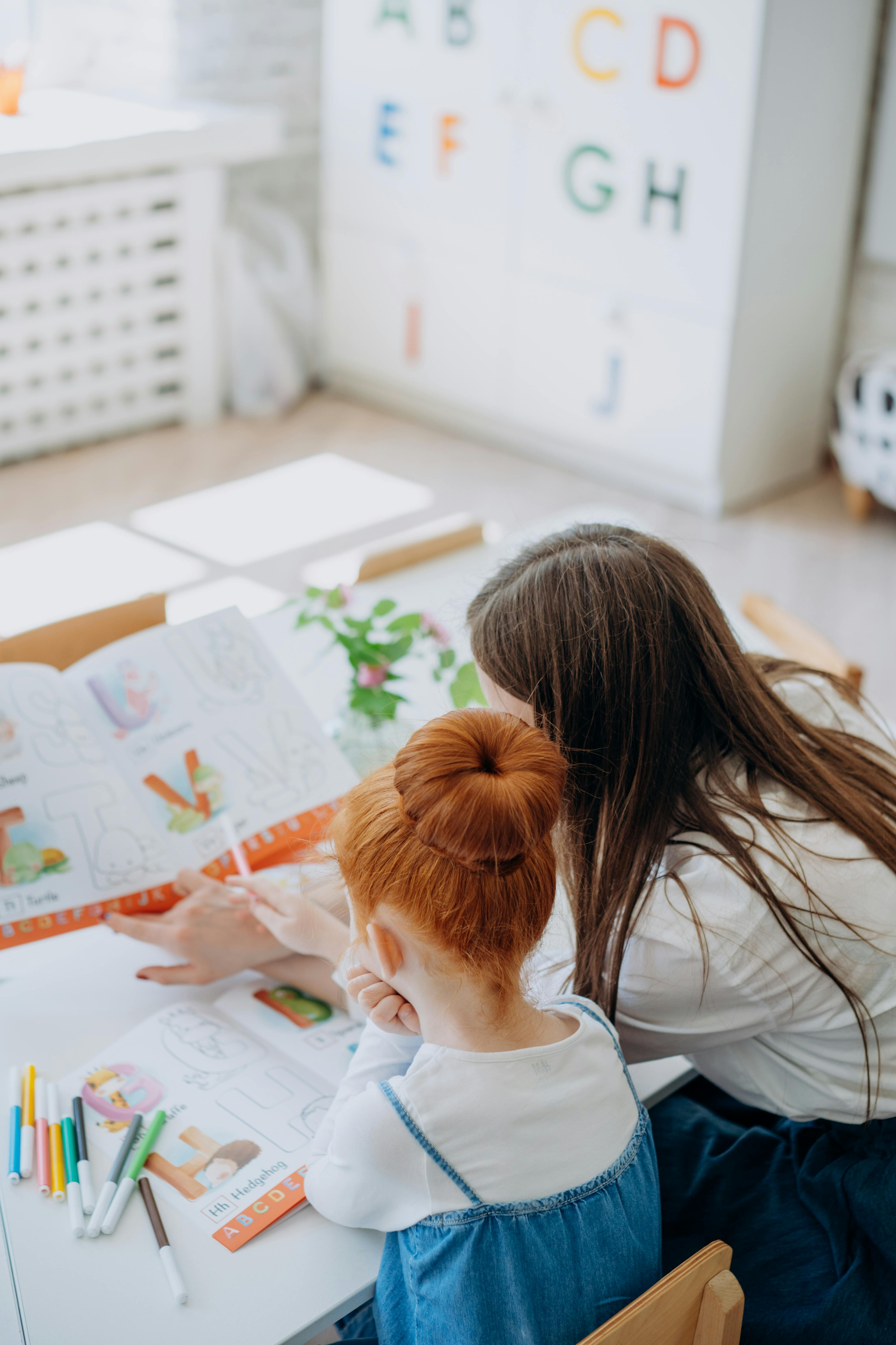 mother and daughter sitting at a desk and doing homework