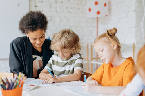 Woman Looking at the Kids Writing