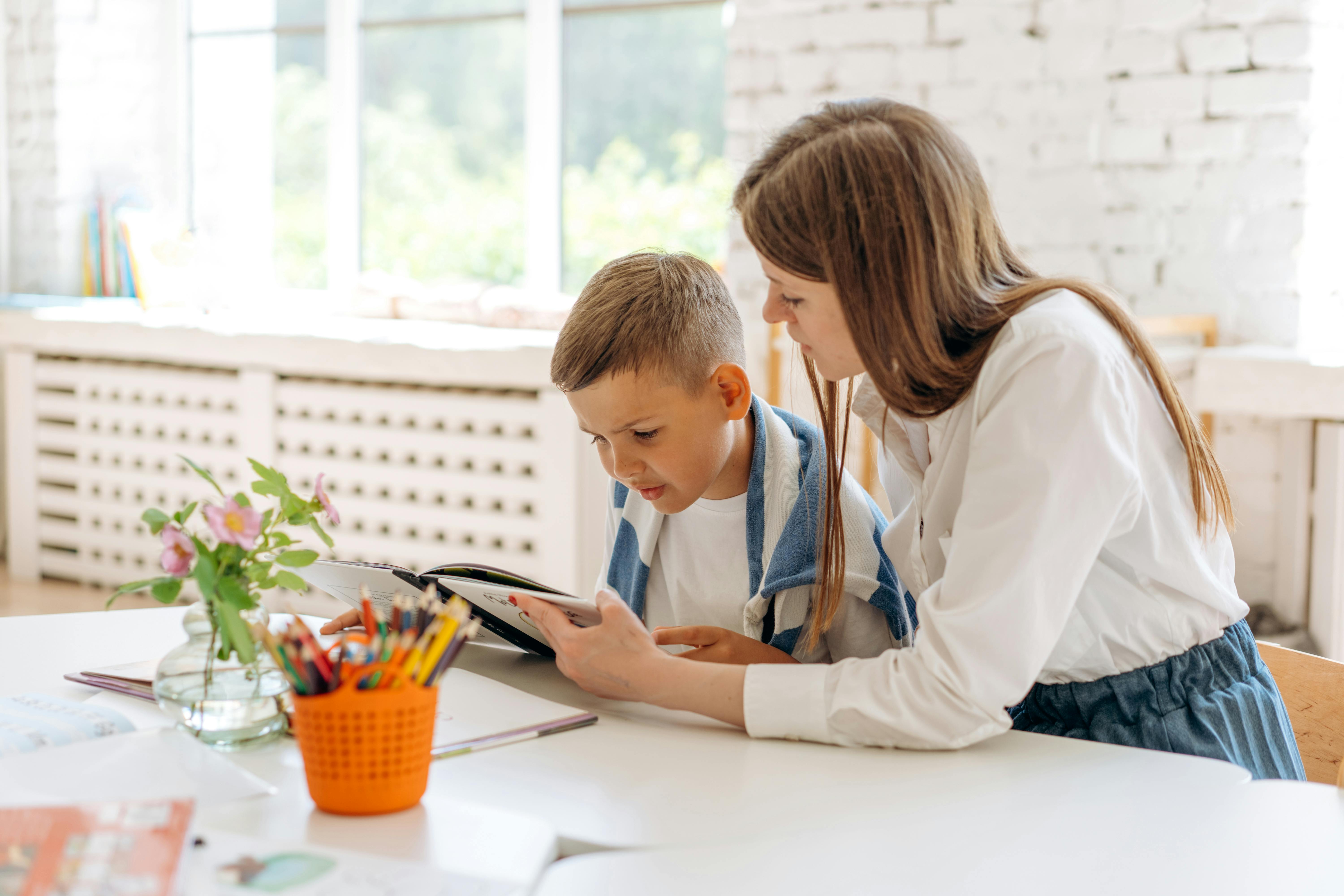 a woman and a boy reading a book