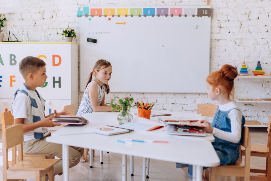 Grundschüler nehmen im Klassenzimmer an Lernaktivitäten an einem Tisch teil.
