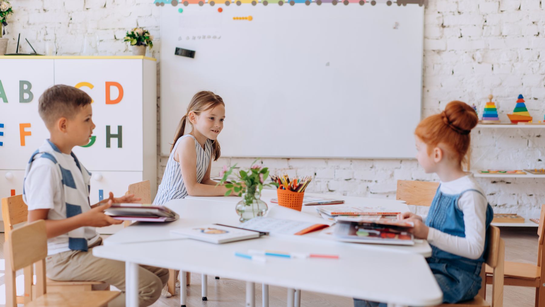 Elementary-age students working together around a classroom table