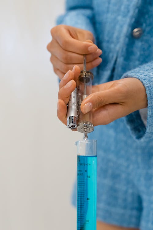 Free Person Drawing Liquid Using Syringe Stock Photo