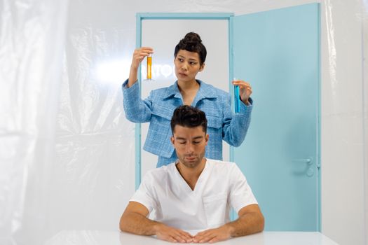 Two scientists conducting an experiment with test tubes in a laboratory setting indoors.