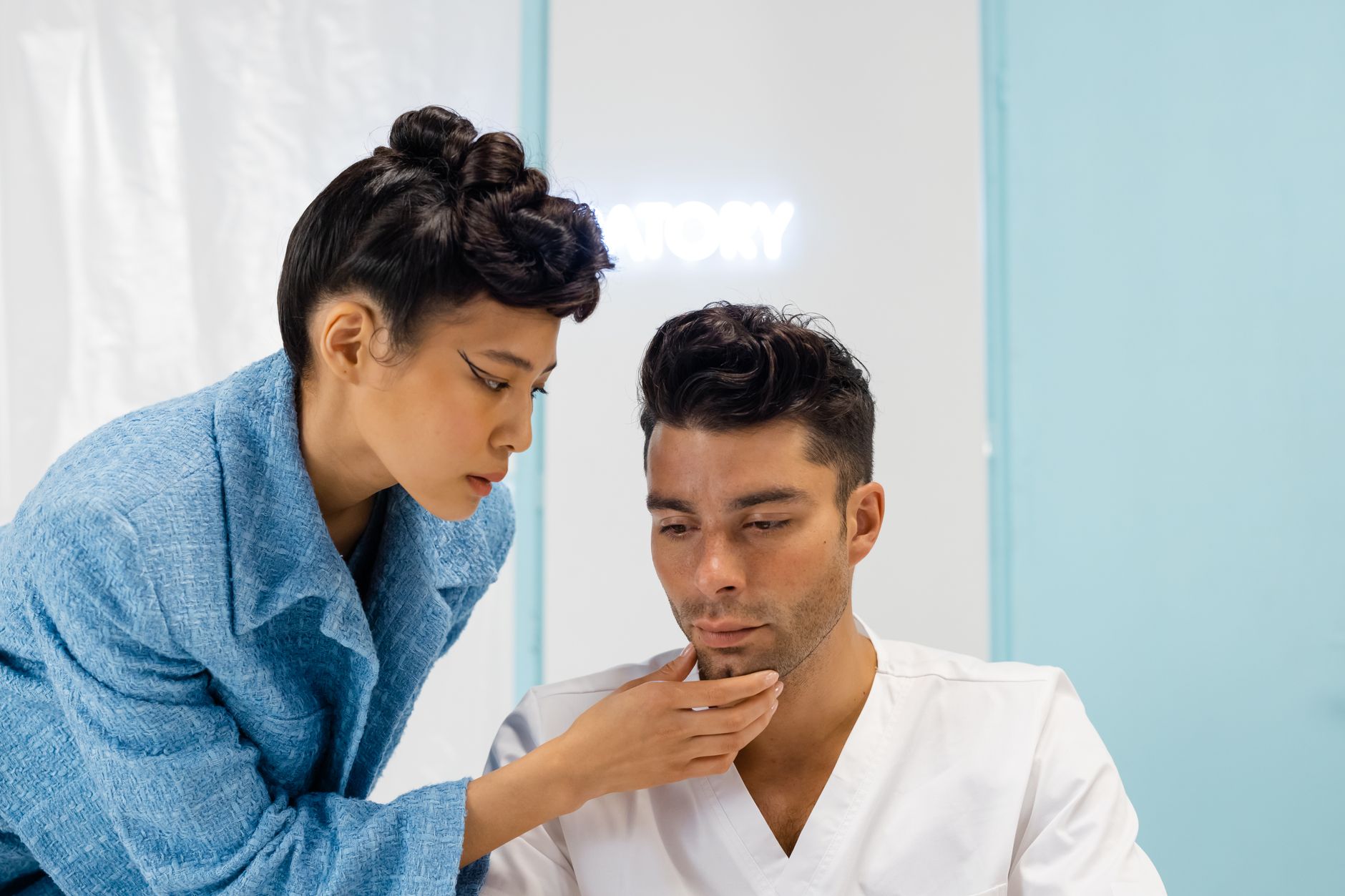 Female doctor in a white coat consulting with a female patient in a modern dermatology clinic, discussing treatment options