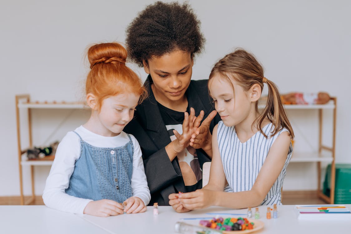 A woman instructs two children on how to play with a colorful toy, fostering learning and engagement in a playful environment.