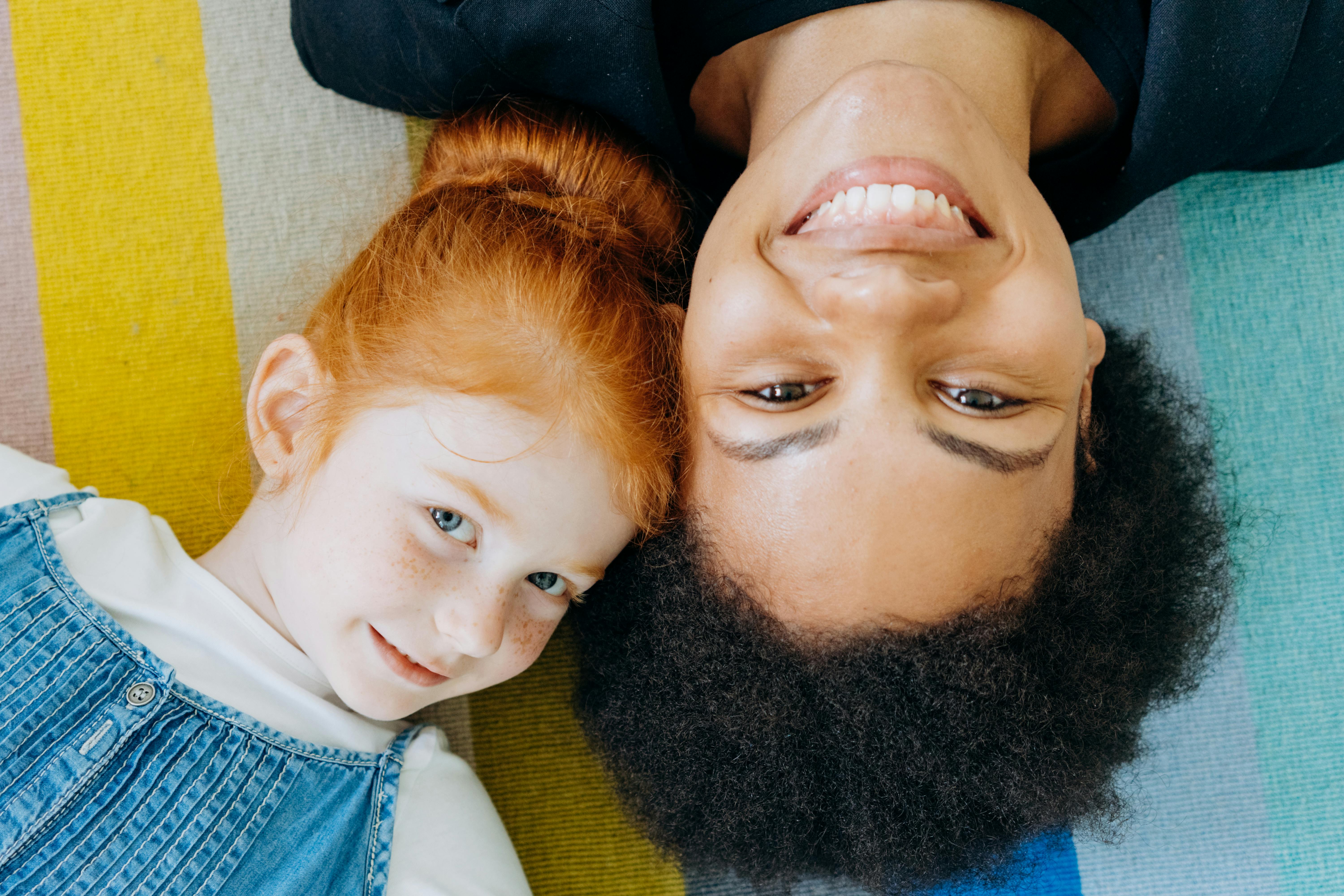 a woman and a girl lying close together in opposite directions