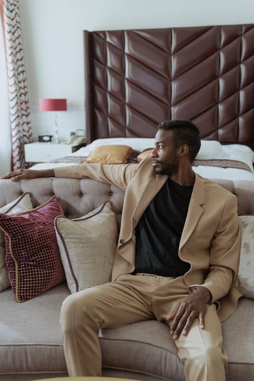 Man in Brown Suit Sitting on Brown Sofa